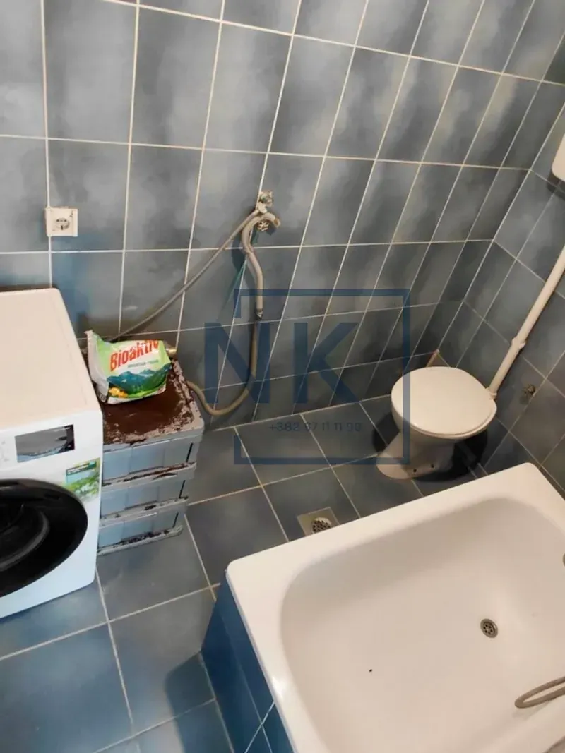 Kupatilo opremljeno kadom, veš mašinom i toaletom.