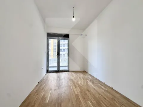 Prazna neopremljena soba sa drvenim podom i balkonskim vratima. - image 3