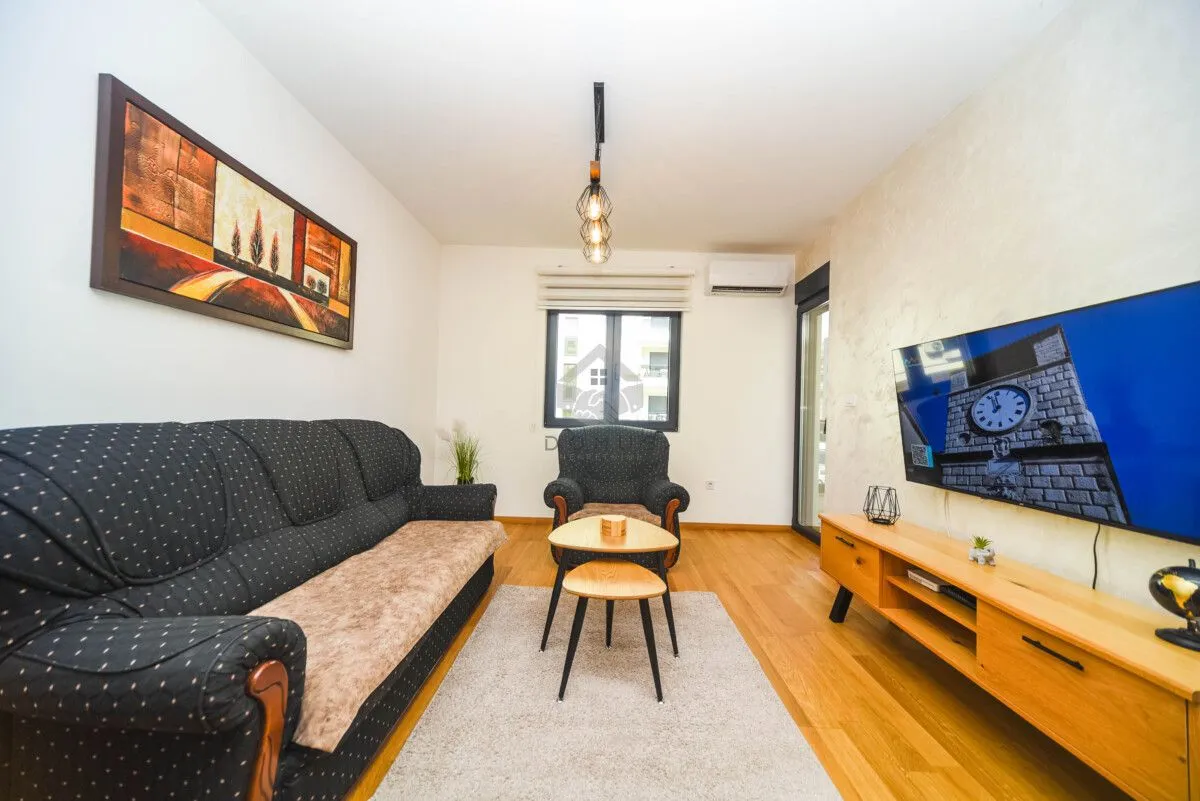 Living room with a sofa set, television, and wooden coffee table.