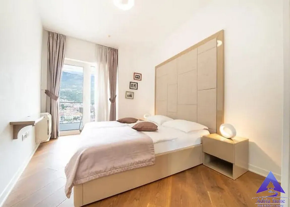 Prostrana spavaća soba sa bračnim krevetom i izlazom na balkon.