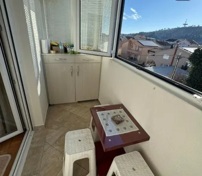 A glazed terrace with a small table and stools. - image 8
