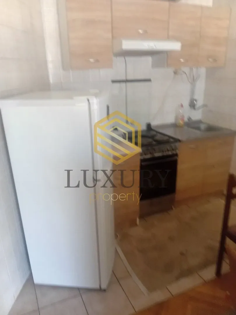 Small kitchen with cabinets and a refrigerator.
