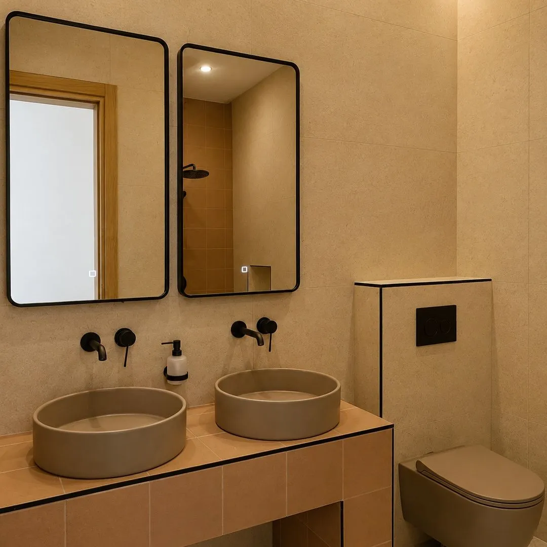 Modern bathroom with two washbasins, mirrors, and a wall-hung toilet in beige tones.
