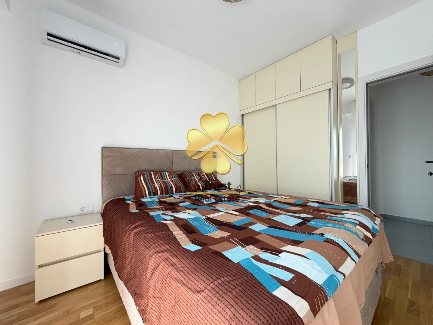 Furnished bedroom with a double bed, wardrobe, and air conditioning.