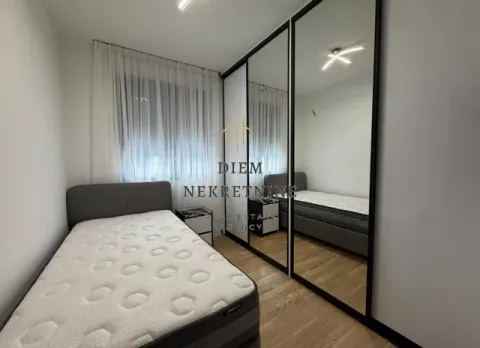 Small bedroom with a bed and a large built-in wardrobe with mirrored doors. - image 9