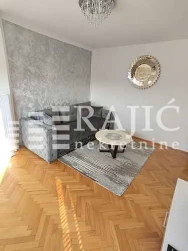 Living room with a sofa and parquet flooring.