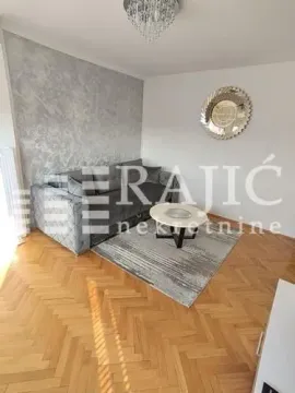 Living room with a sofa and parquet flooring. - image 3