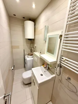 Smaller bathroom with a sink, toilet, shower and washing machine. - image 8