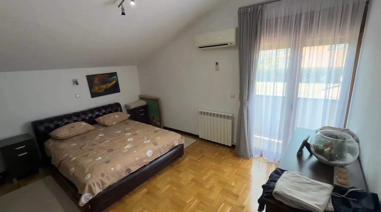 Namještena spavaća soba sa bračnim krevetom i izlazom na terasu.