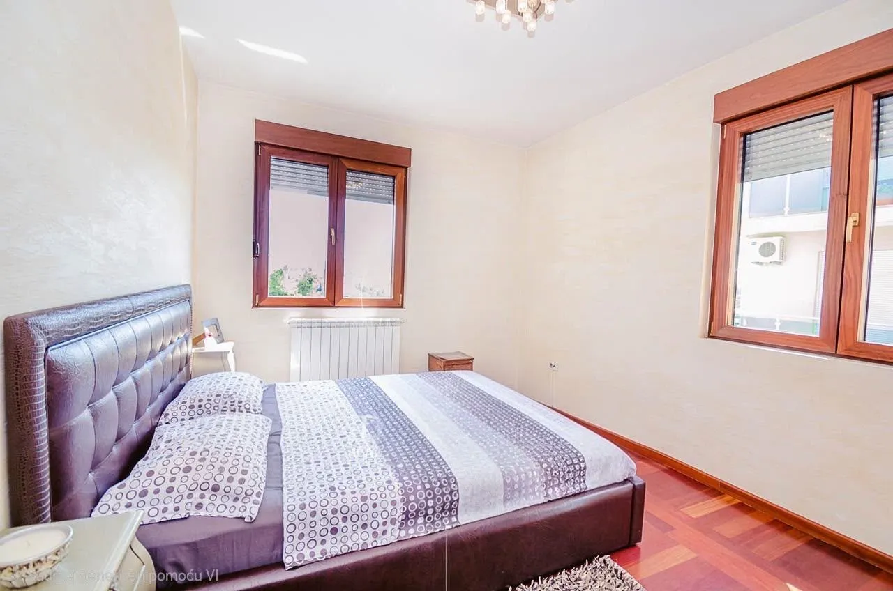 Furnished bedroom with a double bed and windows.