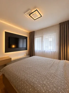 Modern bedroom with a double bed, wall-mounted television, and curtains. - image 7
