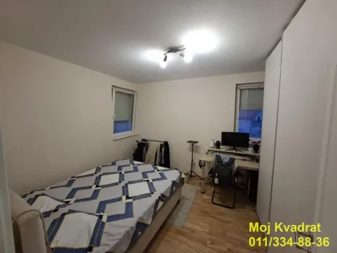 Nameštena spavaća soba sa krevetom, radnim stolom i ormarom. - image 9