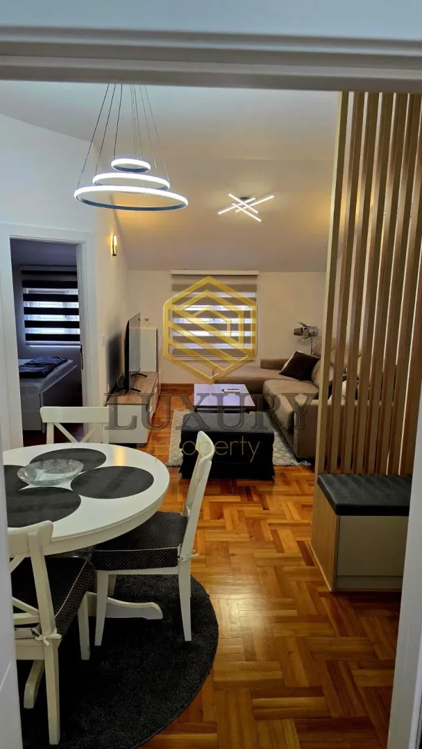 Dnevni boravak povezan sa trpezarijom i modernim osvjetljenjem.