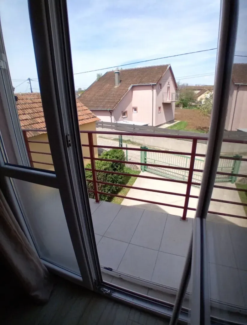Pogled sa balkona na dvorište i susjedne kuće.