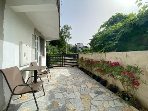 Paved terrace with seating furniture and flowers along the wall. - image 13
