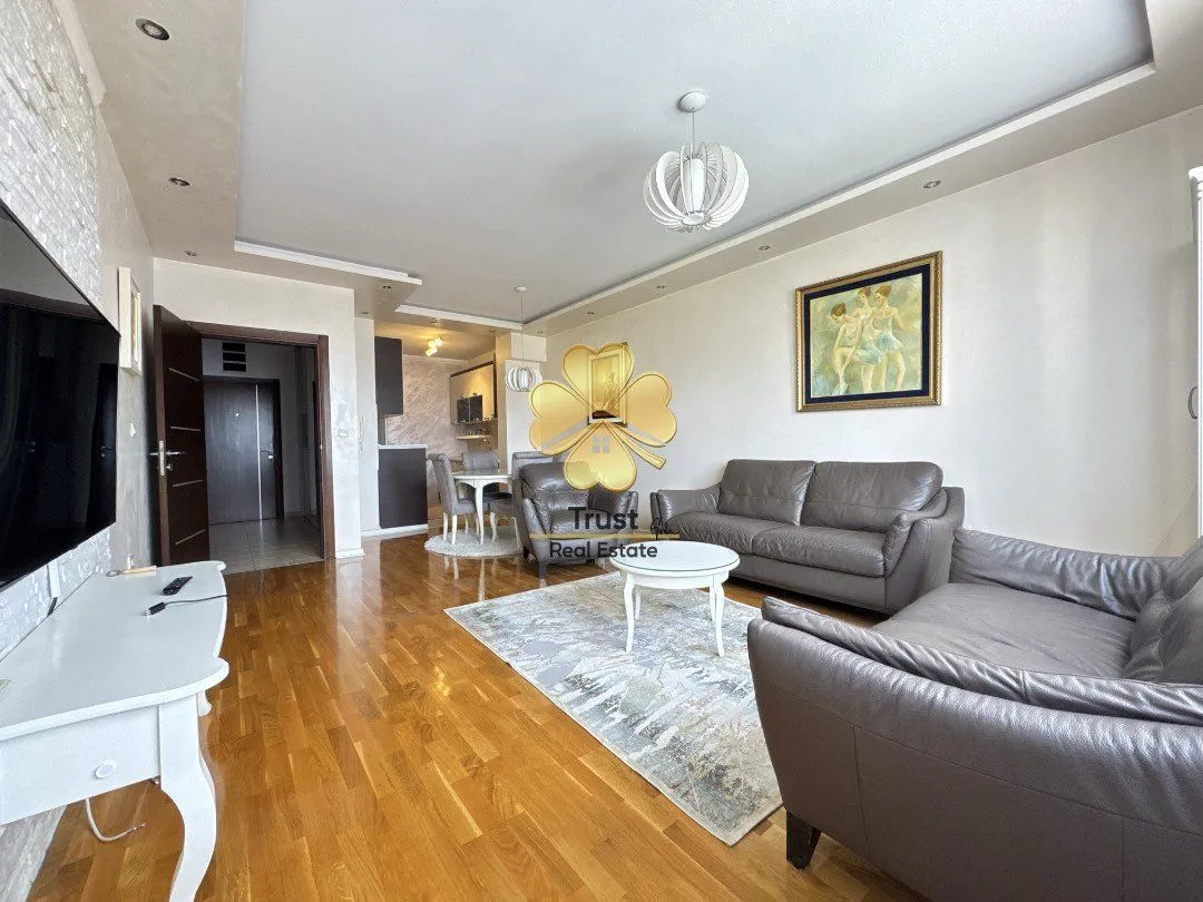 Spacious living room with a sofa set and dining area in the background.