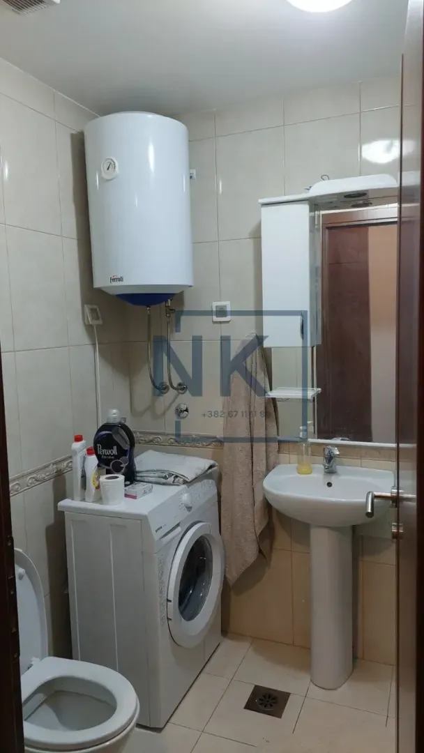 Manje kupatilo sa umivaonikom, WC šoljom, veš mašinom i bojlerom.
