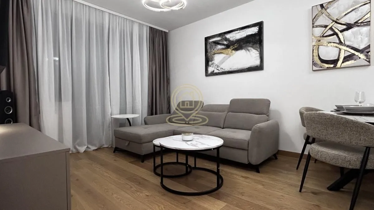 Living room furnished with a grey sectional sofa, coffee table and dining table.