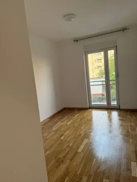 Empty room with hardwood floors and balcony doors. - image 6