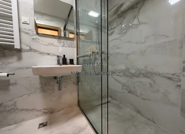 Modernly equipped bathroom with a walk-in shower and washbasin.
