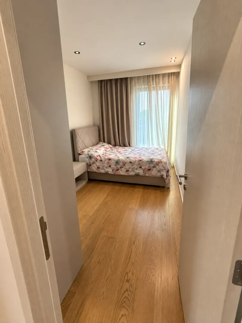 Pogled iz hodnika na namještenu spavaću sobu sa bračnim krevetom.