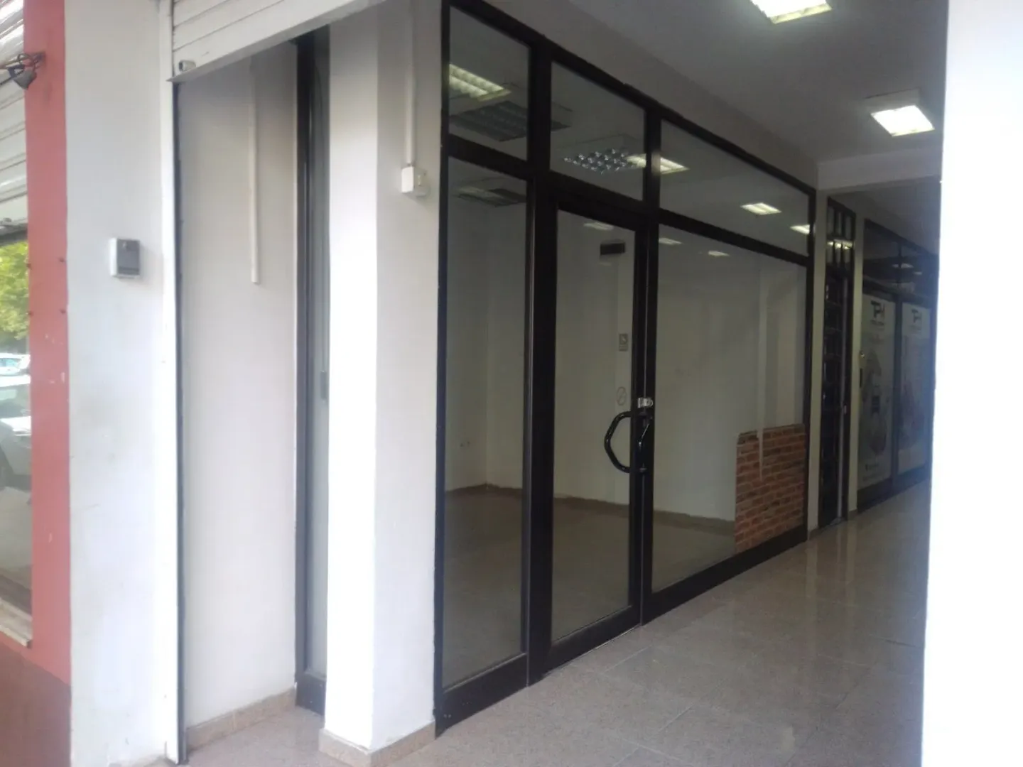 Entrance to a commercial space with glass doors and black frames.