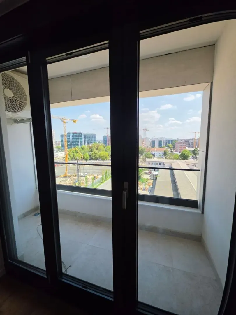 Manji natkriveni balkon sa pogledom na grad i građevinske radove.