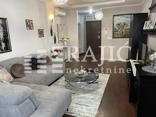 Furnished living room with a sectional sofa and TV unit.