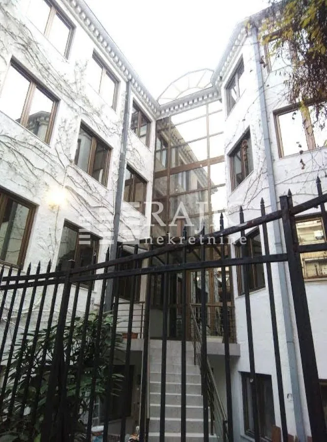 Exterior view of a multi-family building with a courtyard and fence.