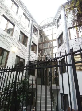 Exterior view of a multi-family building with a courtyard and fence. - image 2