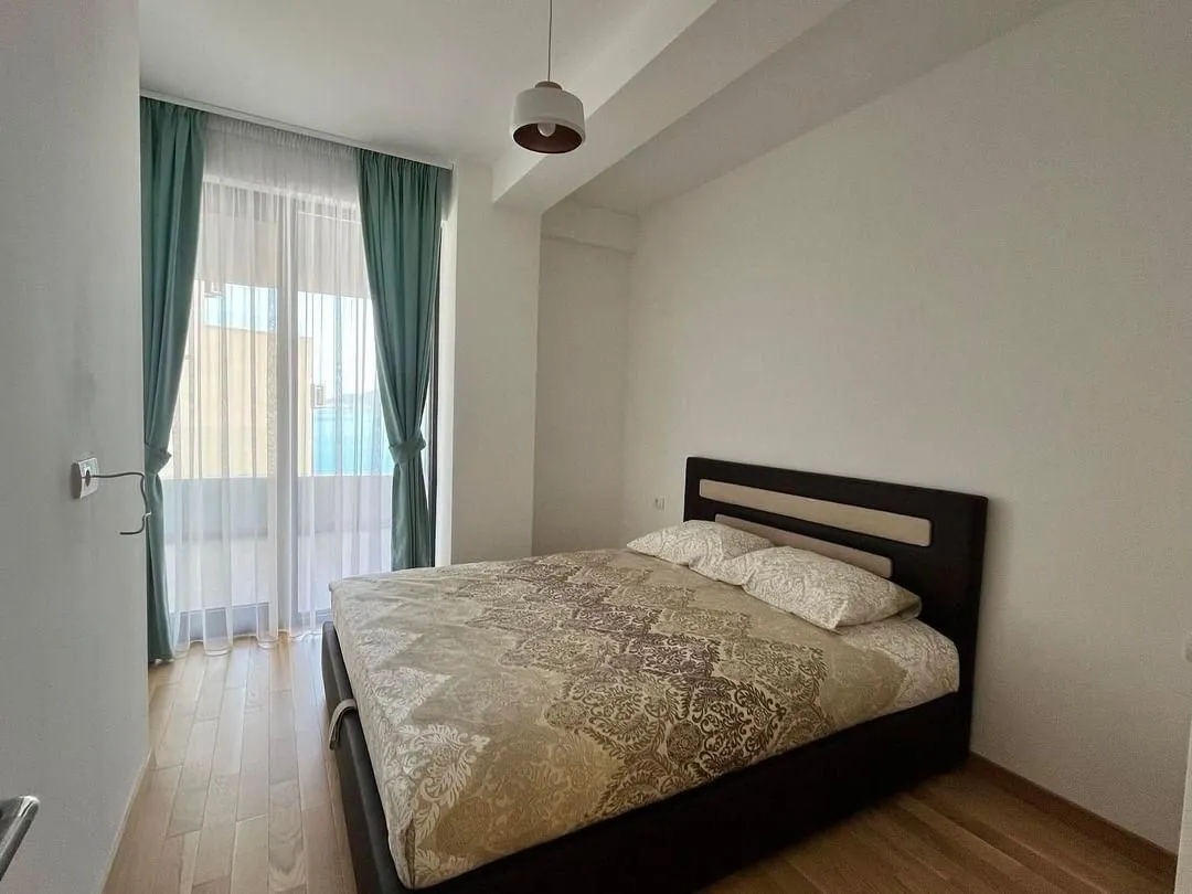 Spavaća soba sa bračnim krevetom i izlazom na terasu.