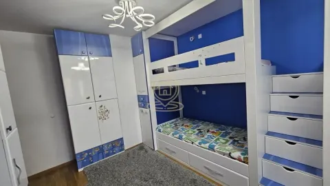 Children's bedroom with a bunk bed, built-in wardrobes, and a rug. - image 3
