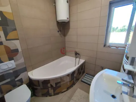 Bathroom equipped with a bathtub, washbasin, toilet, and water heater. - image 33
