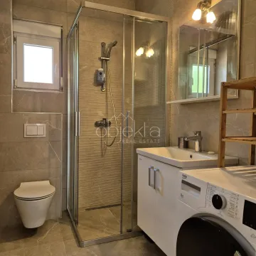 Savremeno opremljeno kupatilo sa tuš kabinom, umivaonikom i veš mašinom. - image 12