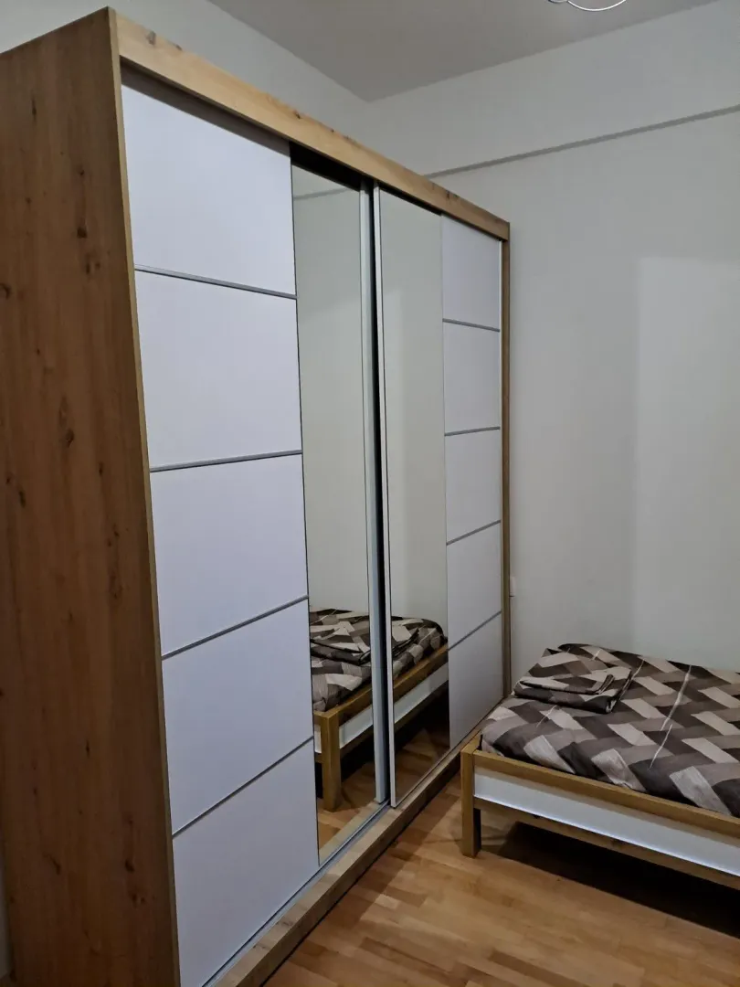 A bedroom with a large wardrobe and a single bed.