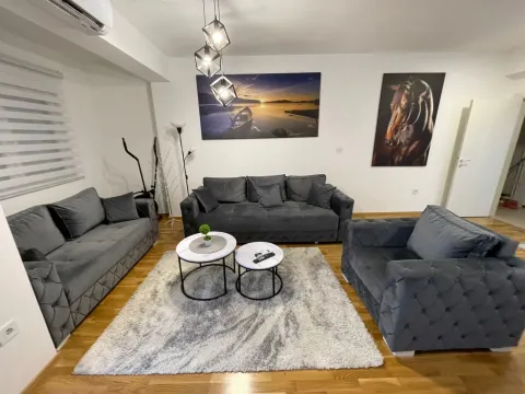 Dnevna soba sa garniturom za sjedenje, stočićima i slikama na zidu. - image 13