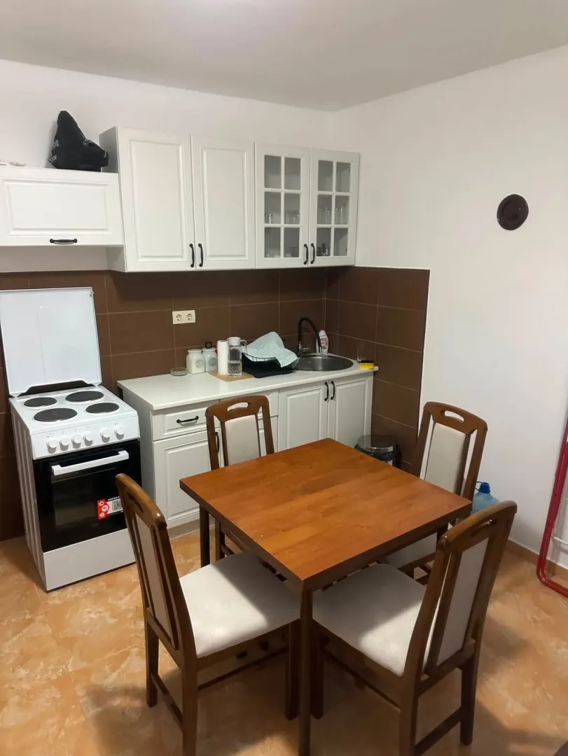 Small kitchen with a dining table and white kitchen cabinets.