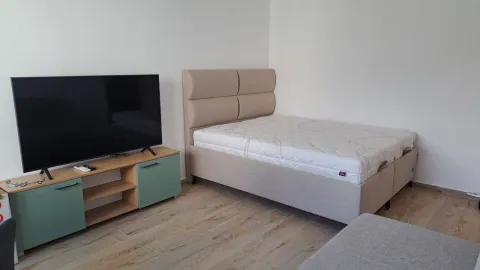 Spavaća soba sa bračnim krevetom, komodom i televizorom. - image 6