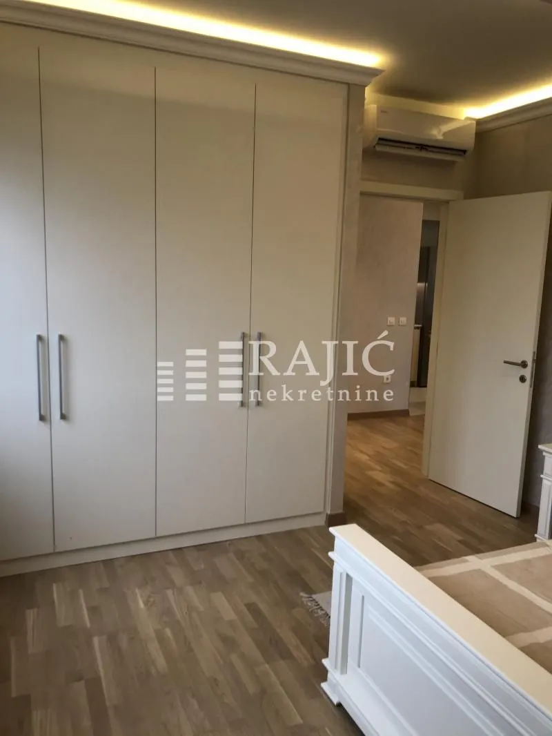 Furnished bedroom with a large built-in wardrobe and a double bed.
