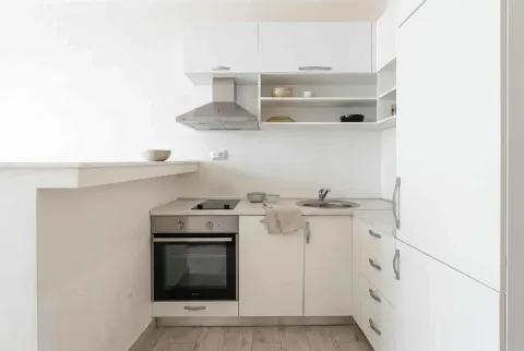 Modern white kitchen with built-in appliances and cabinetry. - image 3