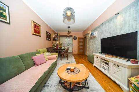 Dnevna soba sa garniturom, stočićem, TV-om i trpezarijom u pozadini. - image 9