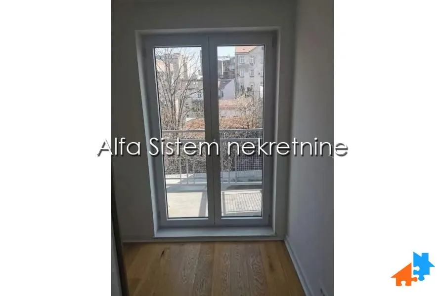Balkonska vrata sa izlazom na terasnu i pogledom na gradsko okruženje.