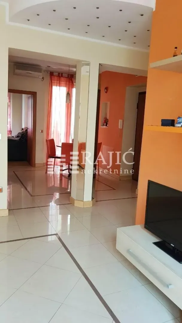 A view of the bright living room and dining area in the apartment.