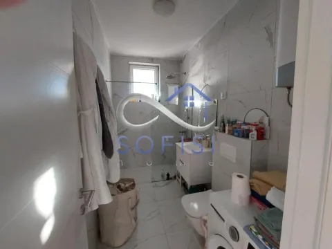 Moderno kupatilo obloženo keramičkim pločicama sa tuš kabinom, sanitarijama i veš mašinom. - image 9