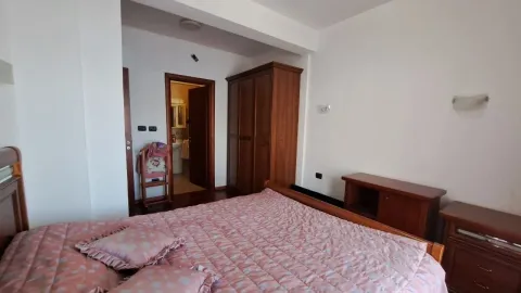 Namještena spavaća soba sa bračnim krevetom, drvenim garderoberom i prolazom prema kupatilu. - image 10