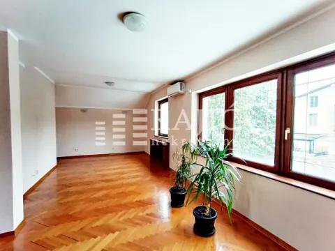 Empty living room with wooden parquet flooring and large windows. - image 14