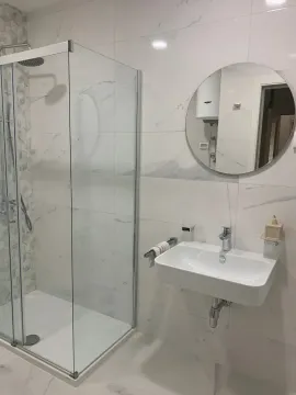 Modernly equipped bathroom with a shower cabin and sink. - image 10