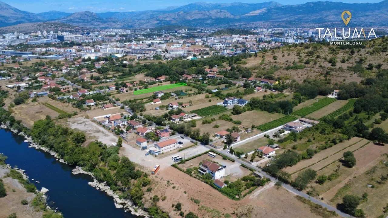 Pogled iz vazduha na grad i okolno naselje sa rijekom.