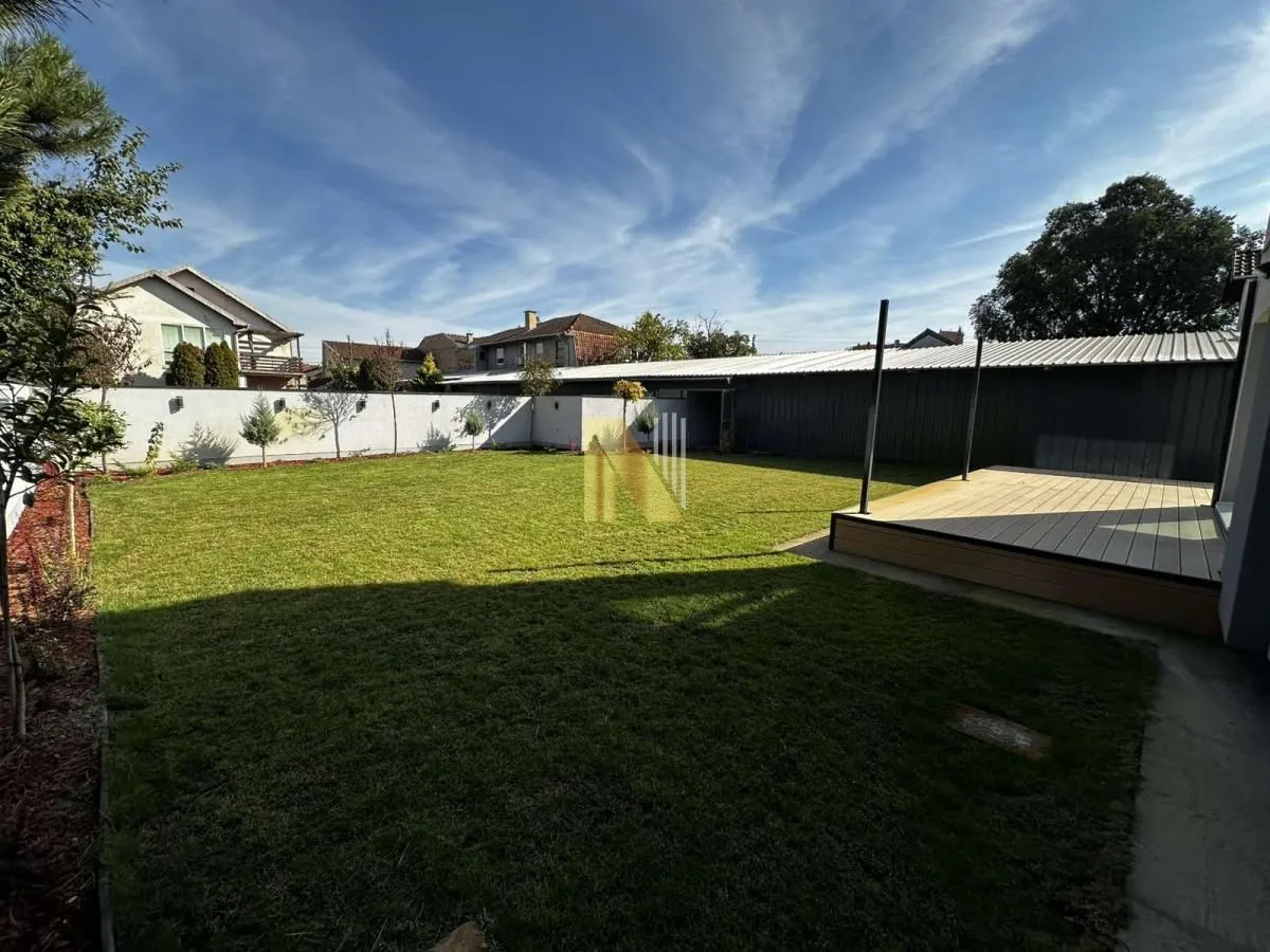 Landscaped yard with lawn and wooden platform.