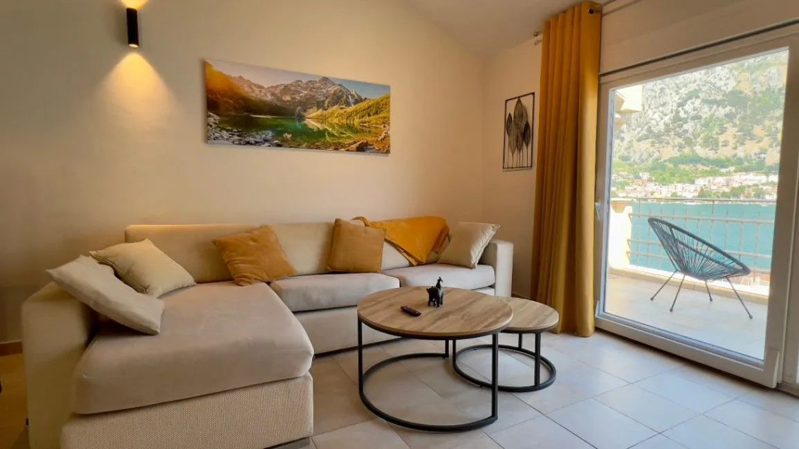 Bright living room with a sectional sofa, coffee table, and access to a terrace with a sea view.